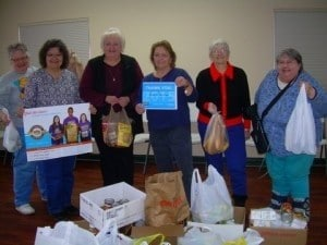Senior volunteers gathered with grocery donations at a community drive