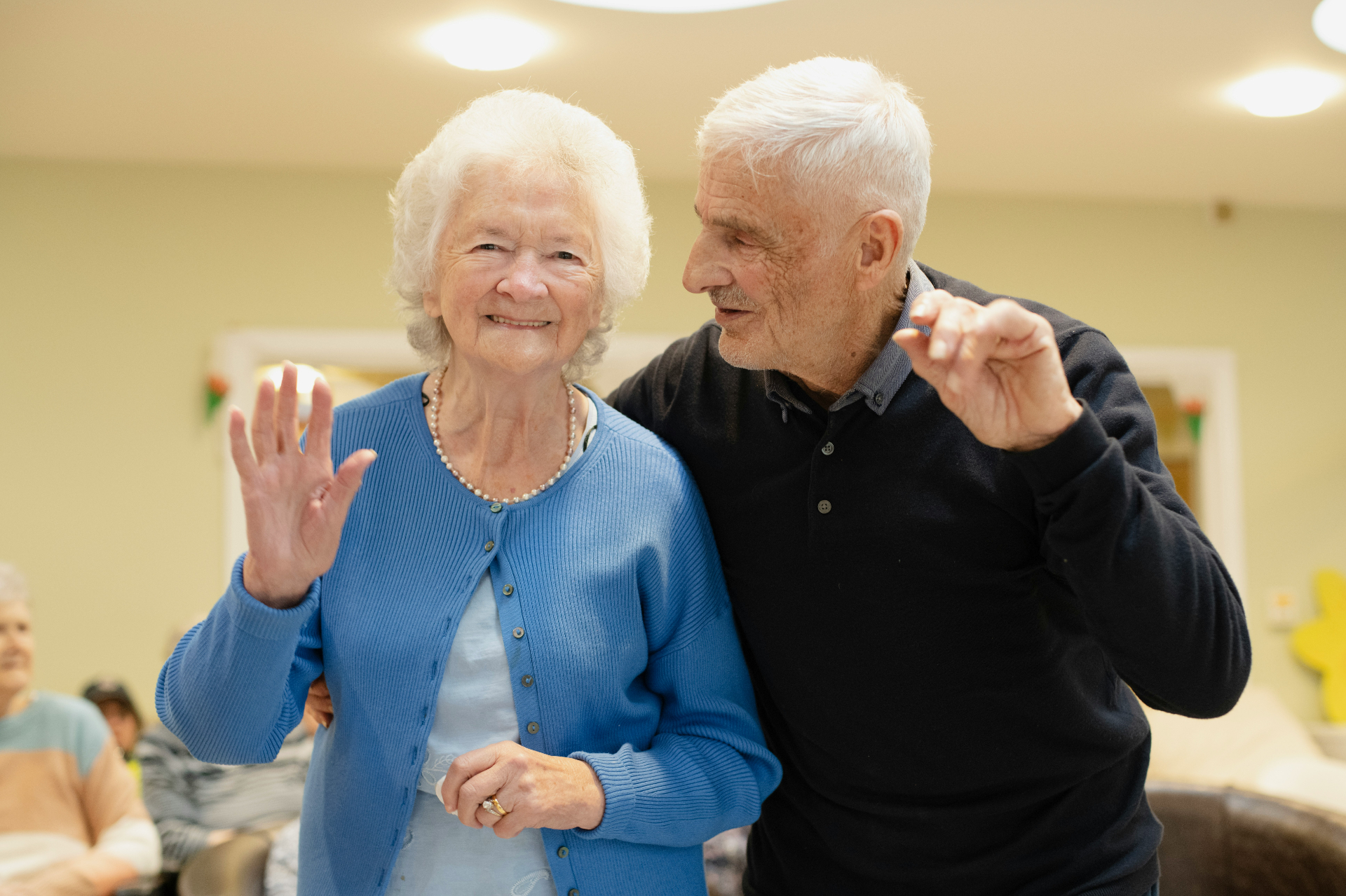 Smiling senior couple dancing together at a community center
